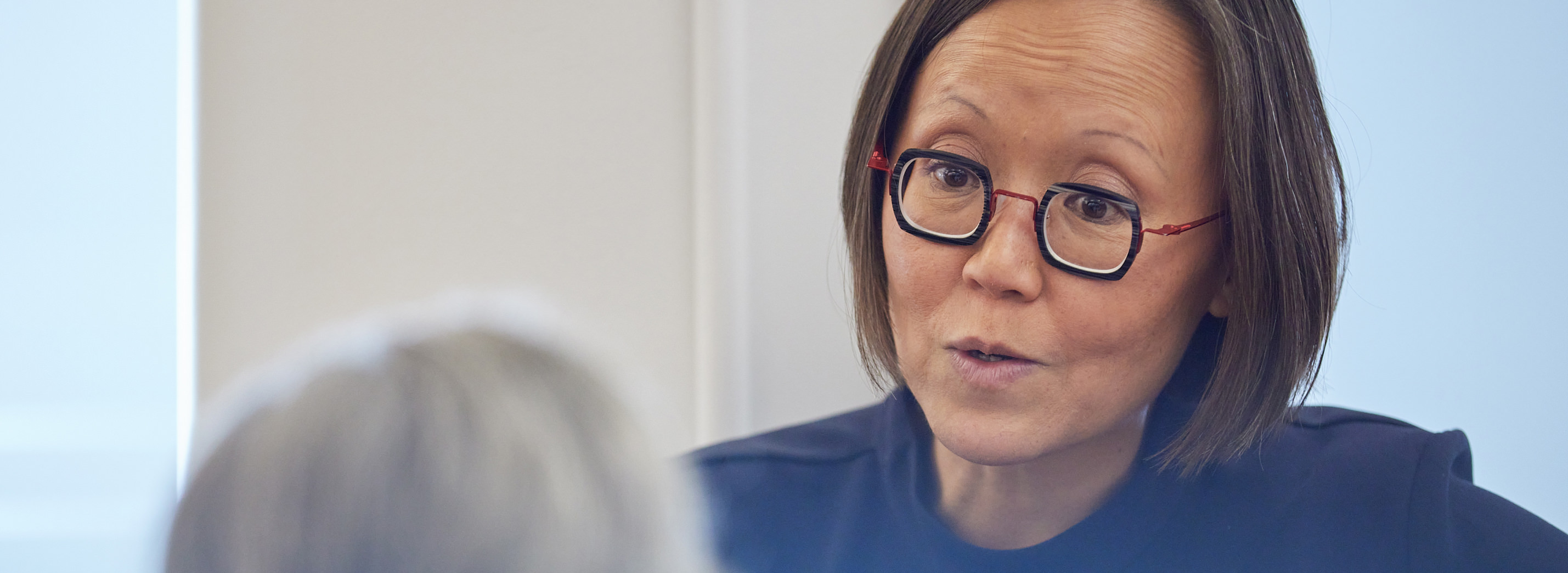 woman with glasses talking to someone